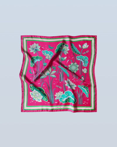 Pink and green Imperial Lotus silk scarf laid flat, printed with lotus blooms, buds and leaves