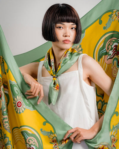 Green and yellow Dragon Dreams silk scarf folded into a band and knotted at the neck