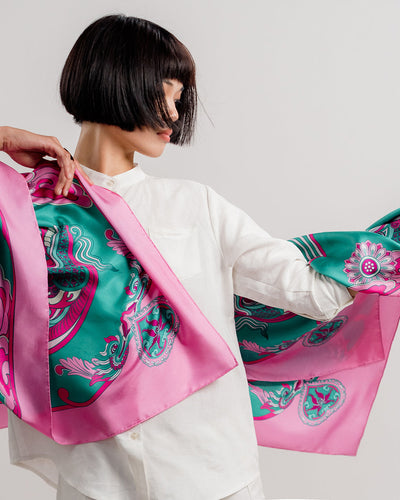Pink and turquoise Dragon Dreams silk scarf, 44 inch square, held open across the shoulders