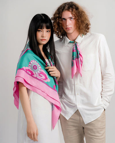 Man with a pink and turquoise Dragon Dreams silk scarf gathered through a ring under an open white collar