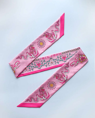 Pink Phoenix Dance silk twilly laid flat, a long narrow strip of printed silk