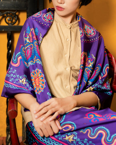 Purple Phoenix Dance silk scarf draped over the shoulders of a woman in a beige shirt