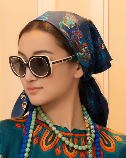 Navy Dragon of Grace silk scarf tied over the head and knotted at the nape