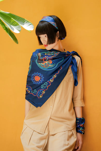 Woman with a black bob wearing the navy Dragon of Grace silk scarf as a headband