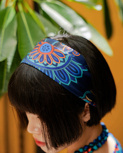 Top-down close view of the navy silk headband with a lotus medallion