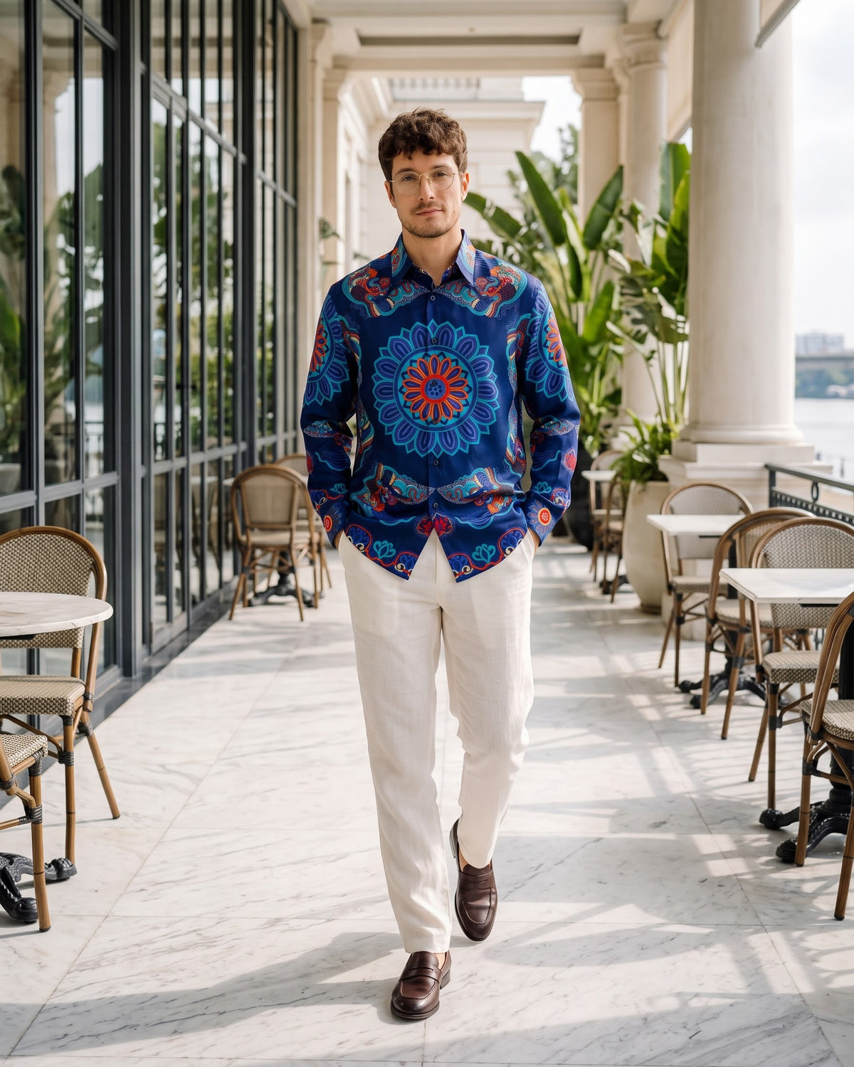 Men's navy Dragon of Grace silk shirt, walking along a hotel brasserie colonnade