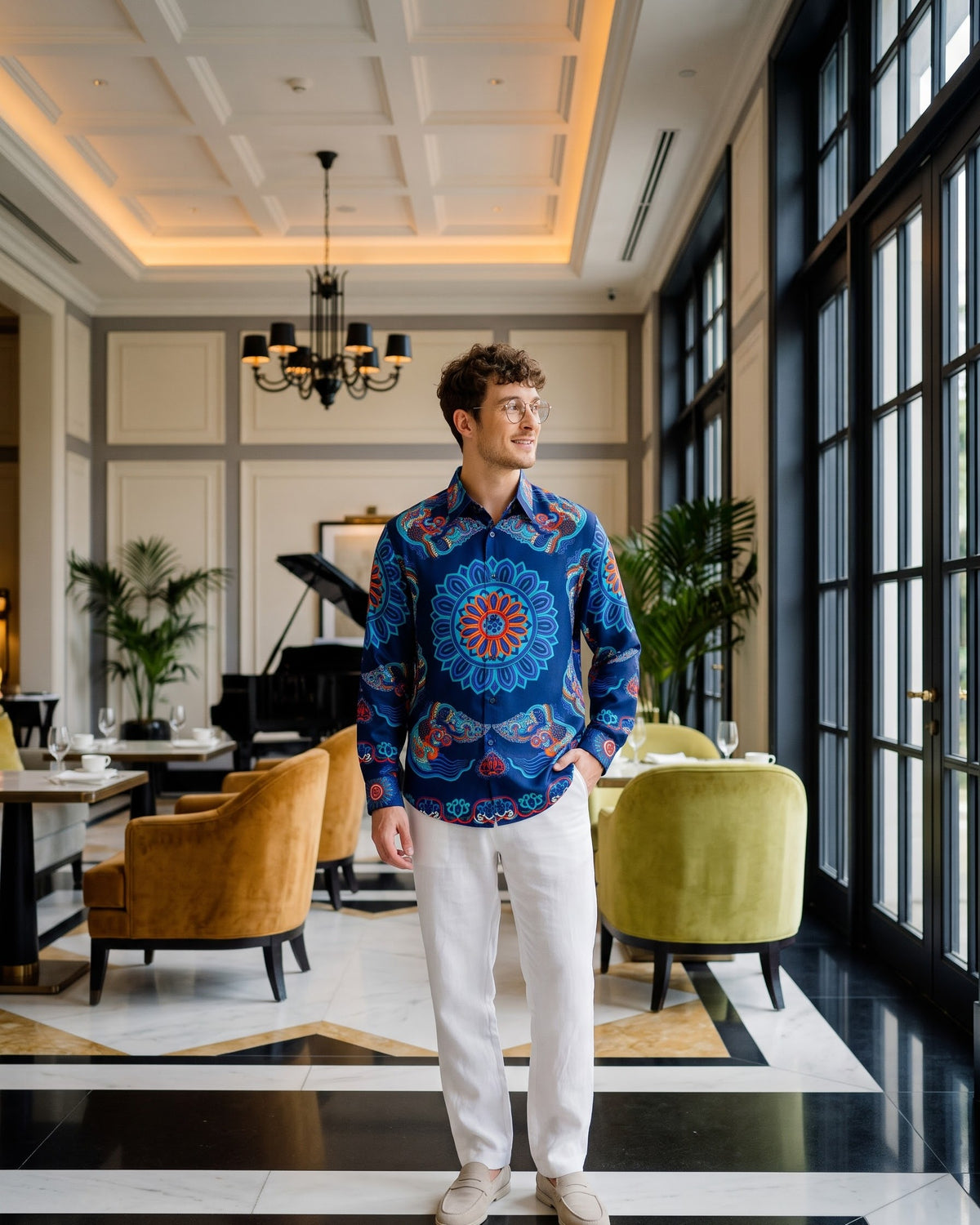Men's navy silk shirt with hand-printed Dragon of Grace, worn in a cream French-colonial tea lounge