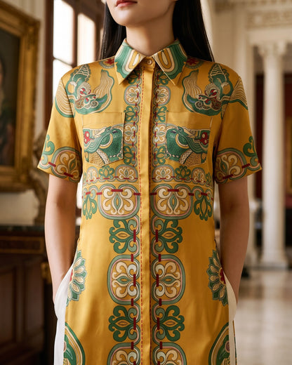 Close view of the mustard-gold satin ao dai: collar, medallion placket and dragon chest pockets