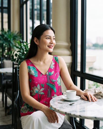 Hot pink Imperial Lotus silk tank top, seated at a marble table in a riverside brasserie