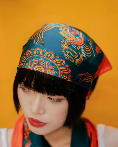 Orange and dark green Dragon Dreams silk scarf, 22 inch square, worn as a head scarf
