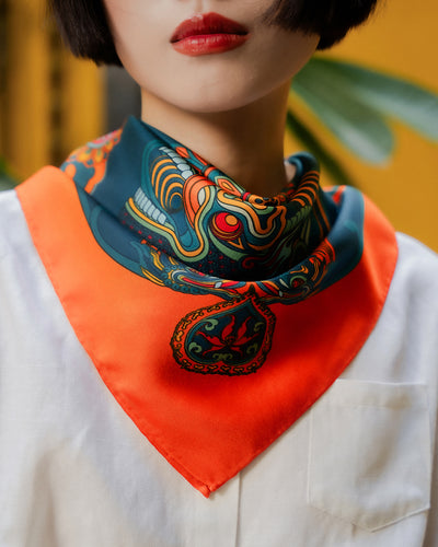 Orange and dark green Dragon Dreams silk scarf, 26 inch square, tied at the neck